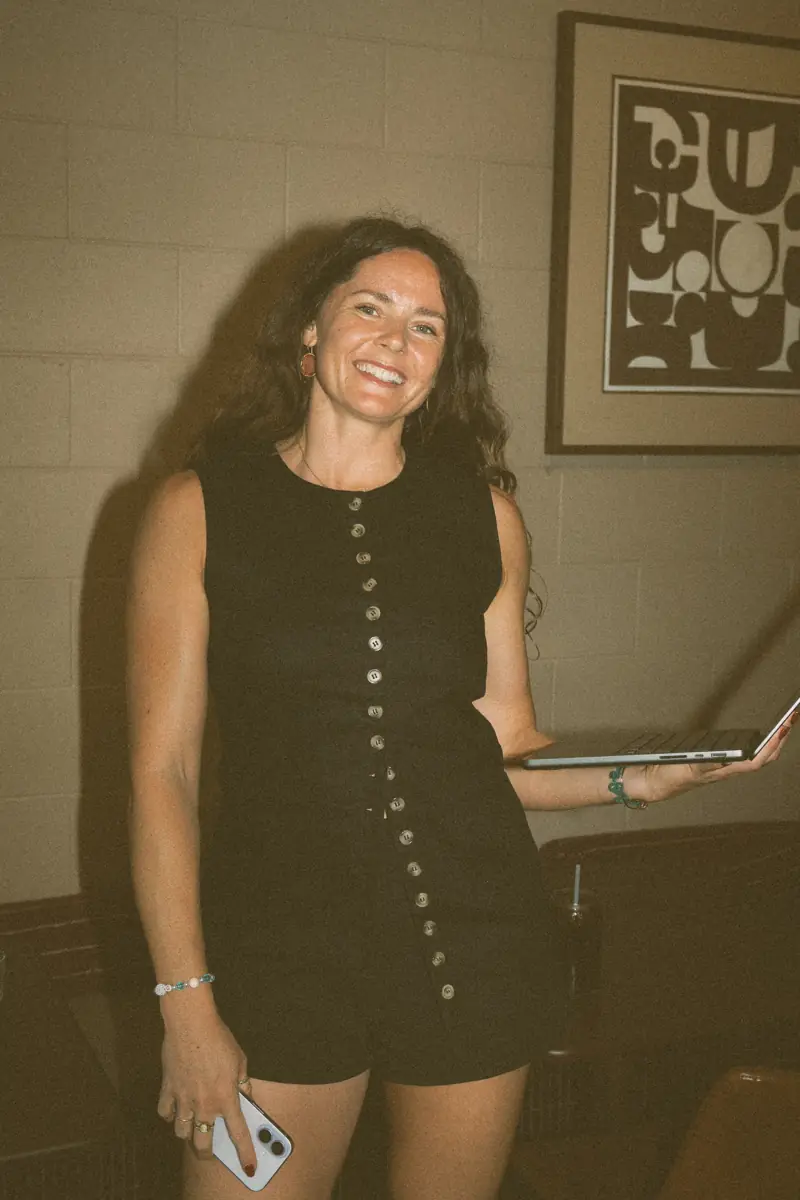 Amy holding her phone and laptop, smiling